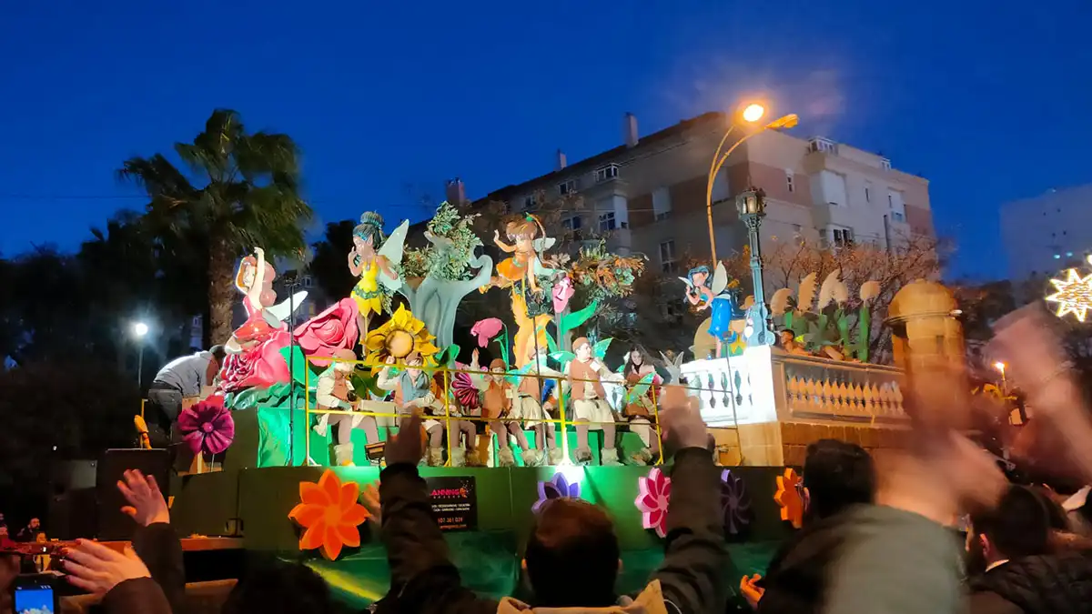 Carroza decorada como un jardín con hadas y elementos de fantasía desfilando en la Cabalgata.