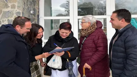 Personas firmando contra los recortes de la sanidad.