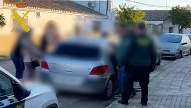 Agentes de la Guardia Civil introducen a los detenidos en un coche.