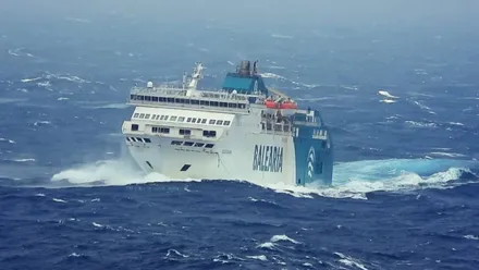 Ferry, en color blanco y verde, en un mar agitado.
