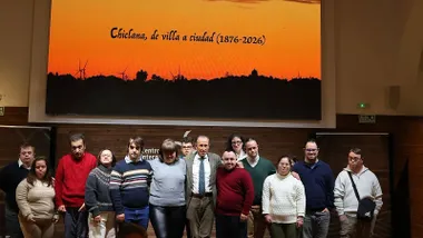 José María Román con los jóvenes de Asodown y la pantalla con la efeméride de Chiclana.