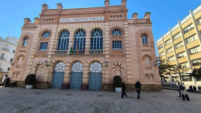 Varias personas miran las estrellas del paseo de la fama del Carnaval ante el Teatro Falla este 8 de enero. Foto: José Luis Porquicho Prada.