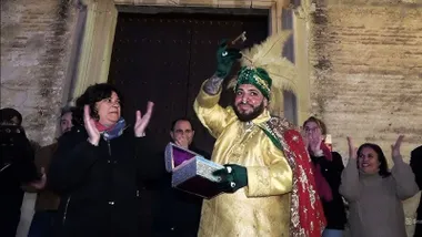 La alcaldesa de Sanlúcar junto al Heraldo Real con ropas doradas.