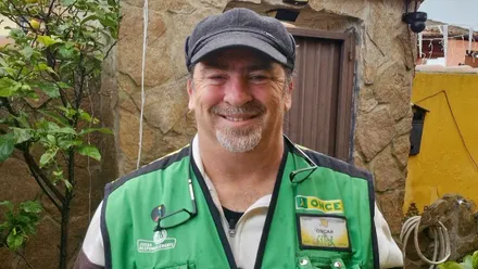 El vendedor de la ONCE, con su chalequillo verde, Óscar Izquierdo, sonríe.