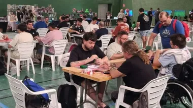 Muchas personas en un pabellón jugando partidas de juegos de rol.