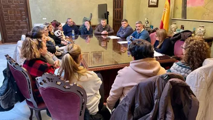 Personas reunidas con el alcalde hablando sobre libertad horaria de los comercios.
