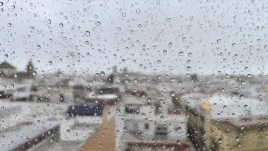Lluvia este domingo 4 de enero en Cádiz, con la catedral al fondo vista a través de un cristal cubierto de gotas, en una jornada marcada por los avisos meteorológicos por el paso de la borrasca Francis.