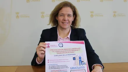 Manuela Pérez sostiene en sus manos el cartel de los cursos en Chiclana.