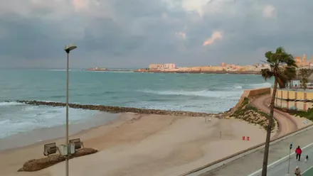 Nubes y olas sobre la playa de Santa María del Mar de Cádiz.