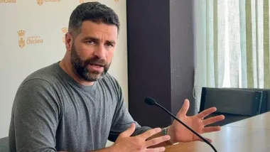 Roberto Palmero hablando sentado en una mesa.