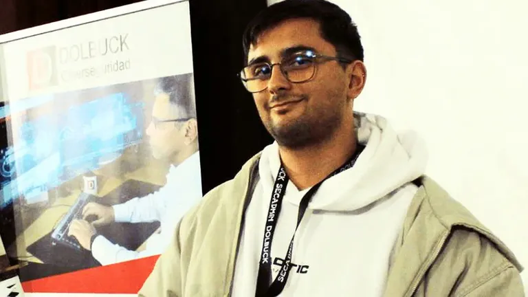 Imagen de Pedro José Navas en SecAdmin, con un cartel de ciberseguridad tras él.