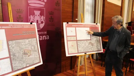 Pizarras con planos y el delegado de urbanismo, de pie, explicando el plan.