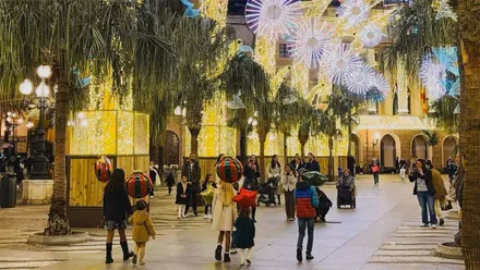 Plaza de San Juan de Dios con alumbrado de Navidad y varias familias con pequeños paseando o haciéndose fotos