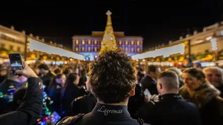 Músico mirando al árbol de Navidad iluminado en la Plaza del Rey de San Fernando.