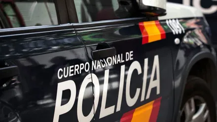 Parte lateral de un coche azul de la Policía Nacional.