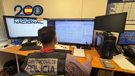 Agente de la Policía Nacional sentado y analizando datos en la pantalla del ordenador.