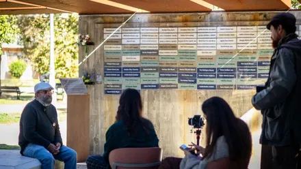 Equipo de grabación, dos chicas y un hombre, entrevistando a un familiar de un represaliado.