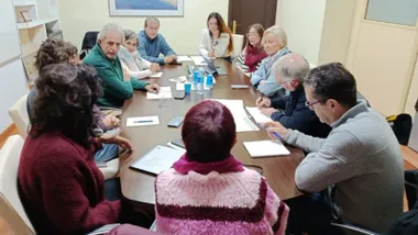 Miembros reunidos en torno a una mesa para dialogar sobre las viviendas para mayores.