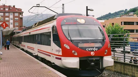 Tren, de color blanco y rojo, en el apeadero de la estación.