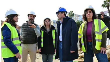 El alcalde de Cádiz, Bruno García, aparece durante la visita a las obras de las 53 viviendas sociales de la avenida de Marconi. Junto a él se encuentran la presidenta de Procasa y concejala de Vivienda y Desarrollo Sostenible, Ana Sanjuán, y la delegada territorial de Vivienda de la Junta de Andalucía, Carmen Sánchez. Los tres observan el avance de los trabajos en el solar, donde se aprecian maquinaria de obra y la zona de excavación correspondiente a la fase de cimentación.