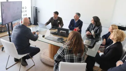 El alcalde mirando una pantalla junto a más personas en una habitación blanca.
