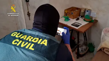 Agente con una cámara digital en la mano haciendo fotos.