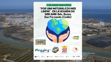 Vista de la Aguada de San Juan con el cartel en primer término, destaca unas manos sosteniendo un planeta en forma de corazón.