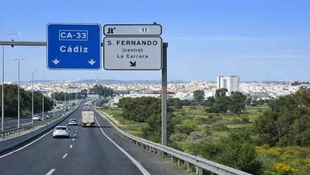 Parte de la CA-33 con carteles indicadores y vehículos circulando.