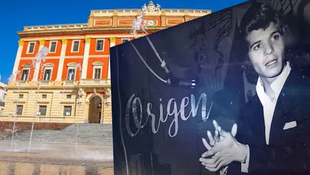 Ayuntamiento de San Fernando con su fachada en color almagra y un cartel en blanco y negro de Camarón con la palabra "Origen".