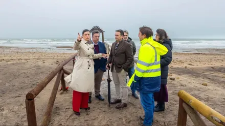 Patricia Cavada junto con los delegados revisando los daños en la playa de Camposoto en un día de mal tiempo.