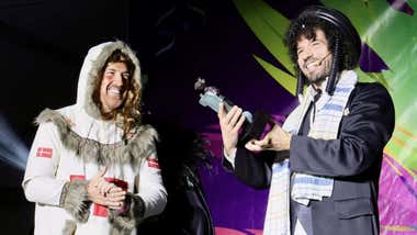 Dos personas en el escenario, uno de ellos con levita de disfraz que recoge el premio.