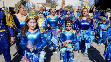 Mujeres y niñas con disfraces azul desfilando por las calles de Rota.