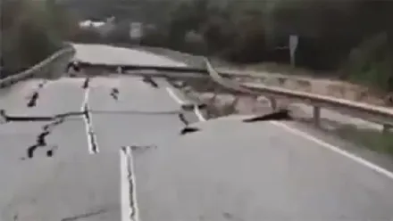 Imagen tomada de un vídeo en la que se observa un hundimiento del asfalto en una carretera de la Sierra de Cádiz. La calzada presenta una grieta profunda y el firme desplazado, con barro y restos de tierra acumulados, lo que impide el paso de vehículos.
