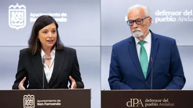 Patricia Cavada y Jesús Maeztu haciendo declaraciones a la prensa en dos atriles delante de un conjunto de pantallas.