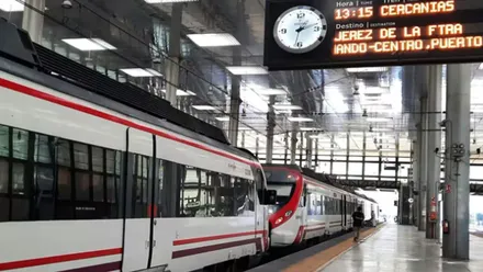 Tren de Cercanías y panel luminoso con horario.