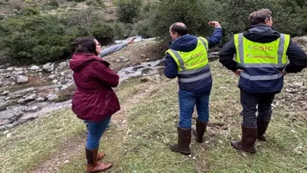Tres personas miran a la Sierra de Grazalema tras comprobar los acuíferos.