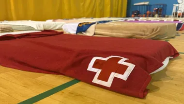 Cama con una manta y la Cruz Rota.