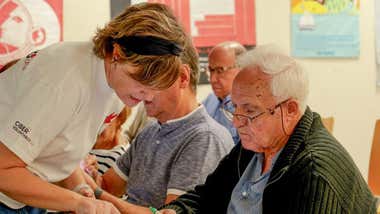 Profesora explicando a un mayor temas de seguridad digital.