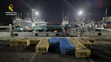 arios fardos de hachís alineados en el suelo junto a agentes de la Guardia Civil.