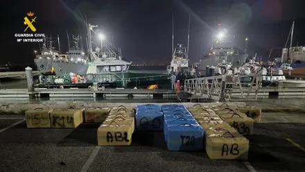 arios fardos de hachís alineados en el suelo junto a agentes de la Guardia Civil.