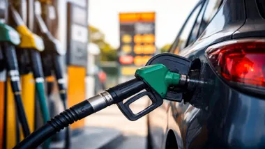 Vehículo azul repostando gasolina Sin Plomo 95 con la manguera verde.