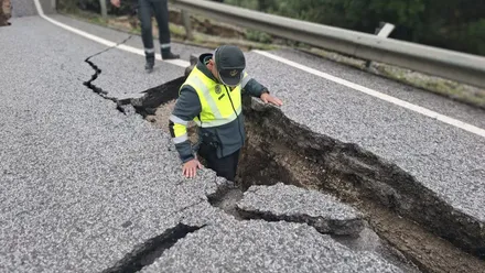 Un guardioa civil comprueba la profundida de una de las grietas en la calzada de una carretera afectada por las consecuencias de los últimos temporales. Foto: Subdelegación del Gobierno.