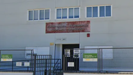 Fachada color hueso con rótulo rojo del IMPRO.