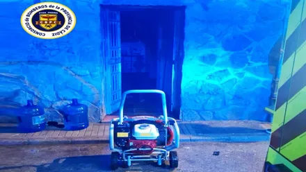 Puerta de la vivienda iluminada con las luces azules de los bomberos.