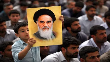Manifestación en la que destaca un niño que sostiene un retrato de Jomeini en Irán.