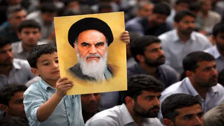 Manifestación en la que destaca un niño que sostiene un retrato de Jomeini en Irán.
