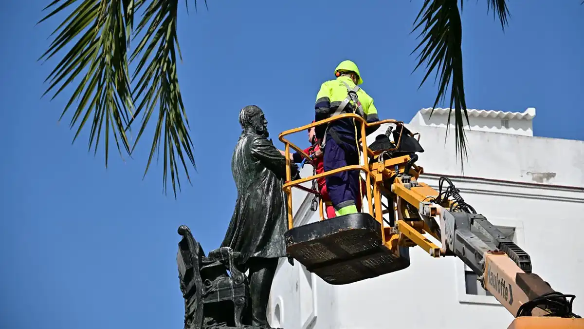 Trabajos de limpieza del monumento a Moret con operarios en plataforma elevadora.