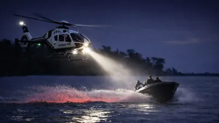 Helicóptero alumbrando a una narcolancha.