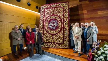 Miembros de la Hermandad y la alcaldesa posando junto al nuevo bordado del palio.