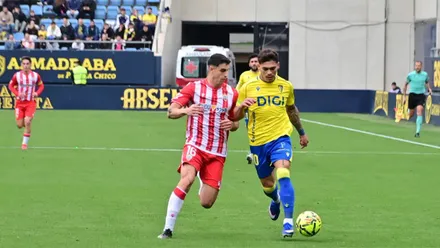 EL jugador del Cádiz CFBrian Ocampo conducen el balón mientras un rival del Almería pugna or robárselo.